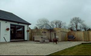 a patio with two chairs and a fence at Knockalla Lodge in Ballygowan