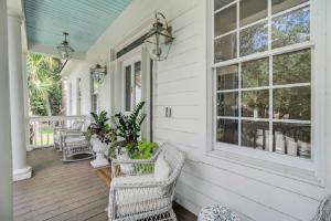 un porche con sillas de mimbre y ventanas en una casa en Fairway Oaks 33 by Wild Dunes, with Amenities, en Isle of Palms