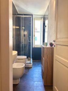 een badkamer met een douche, een toilet en een wastafel bij Nura's - Il Balcone sui Tetti in Alghero