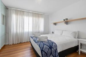 HowrahAbsolute Waterfront Only 15 minutes From Hobart的一间带大床和窗户的白色卧室