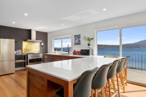 HowrahAbsolute Waterfront Only 15 minutes From Hobart的厨房配有白色的大桌子和椅子