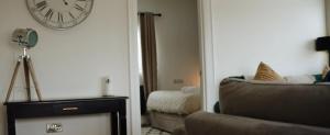 een woonkamer met een klok aan de muur en een bank bij Knockalla Lodge in Ballygowan +20 foto's