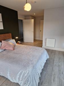 a bedroom with a large bed with a blue blanket at Two Three North in Balgriffin