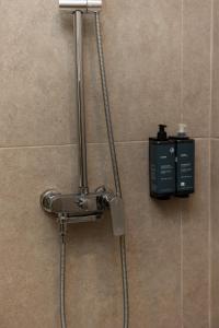 La salle de bains est pourvue d'une douche et d'une boîte noire. dans l'établissement Nexus Apartments, à Thessalonique