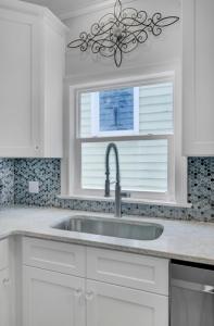 Una cocina blanca con fregadero y ventana. en Grand Pavilion 10 by Wild Dunes, Luxury Home, en Isle of Palms