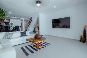 a living room with a white couch and a table at Oceanfront Private Pier Pool Garden Terrace 3BR house in Cancún