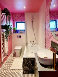 Baño rosa con lavabo y aseo en Private Bedroom & Bathroom with Amazing View in Quirky Townhouse, en Glasgow