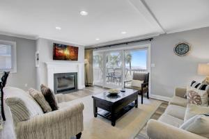 a living room with a couch and a fireplace at Seagrove 1A by Wild Dunes, Oceanfront Condo in Isle of Palms
