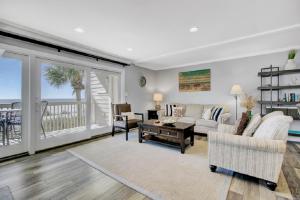 a living room with a couch and a table at Seagrove 1A by Wild Dunes, Oceanfront Condo in Isle of Palms +13 photos