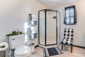 a bathroom with a shower and a toilet and a chair at Kentucky Lake Retreat 4 Mi to Shore Boat and Fish! in New Johnsonville +16 photos