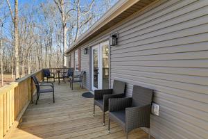 a wooden deck with chairs and a table on it at Kentucky Lake Retreat 4 Mi to Shore Boat and Fish! in New Johnsonville