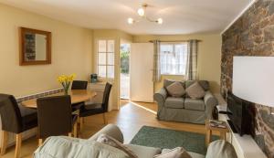 a living room with a couch and a table at Le Douit Farm Self Catering in St. Martin Guernsey