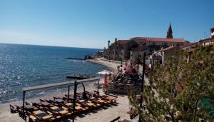 a group of chairs on a beach next to the water at Apartment Nika in Umag