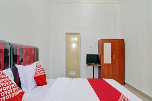 a bedroom with a bed with red and white pillows at Hotel O Lestari Baru Syariah Near SMA Negeri 1 Salo in Bangkinang +16 photos