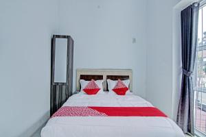 a bedroom with a large bed with red pillows at Hotel O Lestari Baru Syariah Near SMA Negeri 1 Salo in Bangkinang