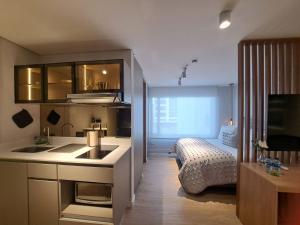 ボゴタにあるBESTAY - Edificio Tribecaのシンク付きのキッチンとベッドが備わった部屋