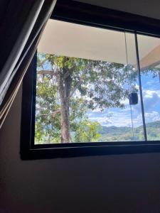 a window in a room with a tree in the background at Chalé Torneados in Tiradentes