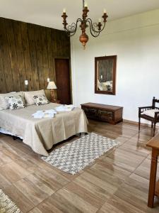 a bedroom with a bed and a chandelier at Chalé Torneados in Tiradentes +13 photos