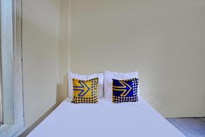 two pillows sitting on a bed in a room at Hotel O Tanjung Indah Homestay Syariah in Banyuwangi +22 photos