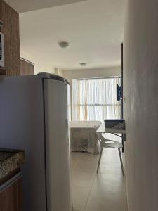 eine Küche mit einem Kühlschrank, einem Tisch und einem Bett in der Unterkunft Excelente AP - Próximo a Shopping, Parque do Povo, Mercado in Campina Grande
