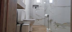 a white bathroom with a toilet and marble walls at Makis Apartments Flogita in Flogita +105 photos