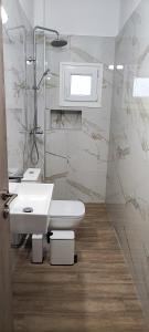 a white bathroom with a sink and a shower at Makis Apartments Flogita in Flogita