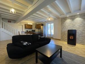 a living room with a black couch and a table at Chez bourdet-pelou in Arette