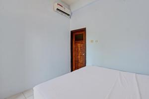 Postel nebo postele na pokoji v ubytování Capital O 92747 Ombak Cafe & Homestay