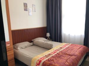 małe łóżko w sypialni z oknem w obiekcie House of Luna Peaceful Villa Tengah Kota Pekanbaru w mieście Pekanbaru +16 zdjęć