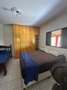 a bedroom with a bed with a blue blanket on it at Lindo sítio em porto feliz in Pôrto Feliz +14 photos