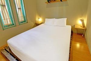 a large white bed in a room with two windows at OYO 92825 Kamar Lombok in Kuripan +21 photos
