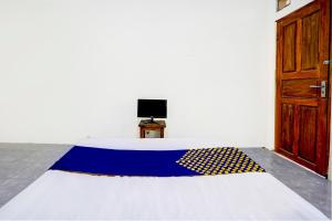 バニュワンギにあるSPOT ON 92855 Griya Sandi Syariah Rogojampiの旗が掲げられたベッドが備わる部屋 +23枚の写真