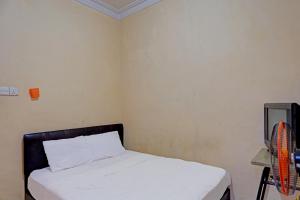 Cette petite chambre comprend un lit avec des draps blancs. dans l'établissement Hotel O Pelita StayNearAnugrah Sinar Lautan, à Nagoya