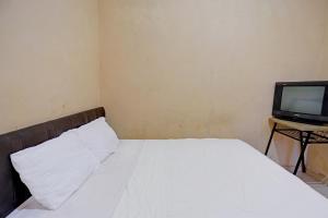 - une chambre avec un lit et une télévision dans l'établissement Hotel O Pelita StayNearAnugrah Sinar Lautan, à Nagoya