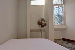 une chambre avec un lit avec un ventilateur à côté d'une fenêtre dans l'établissement Hotel O Pelita StayNearAnugrah Sinar Lautan, à Nagoya 16 autres photos