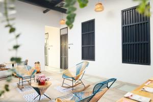 eine Terrasse mit Stühlen und einem Tisch mit Blumen in der Unterkunft Casa Comala in Bucaramanga