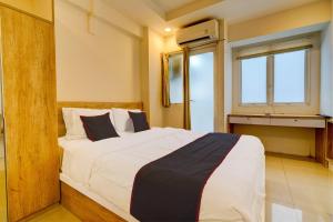 a bedroom with a large bed with a window at Collection O 92870 Apartement Grand Sentraland Karawang By Ipul in Karawang