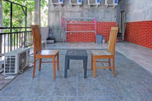 a patio with two chairs and a table and a heater at OYO Life 92877 Hotel Rainbow 7296 in Semarang