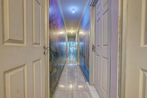 a hallway with an open door and a wall with flowers at OYO Life 92877 Hotel Rainbow 7296 in Semarang