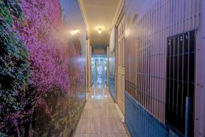 a hallway with purple flowers on the side of a building at OYO Life 92877 Hotel Rainbow 7296 in Semarang