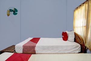 a bed in a room with a blue wall at OYO 92903 Barokah Hotel Syariah in Sangkapura