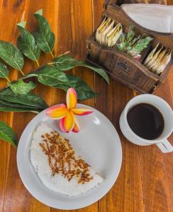 a plate of food with a flower and a cup of coffee at Pousada Porto Verano in Porto De Galinhas +37 photos