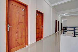 a corridor with a wooden door and a corridor with at Hotel O Penginapan Sarinah SyariahNearRM Beringin Indah in Pelalawan +41 photos