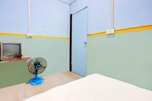 Cette chambre comprend un ventilateur et une télévision. dans l'établissement Hotel O Toyo Homestay Syariah, à Nagoya 22 autres photos