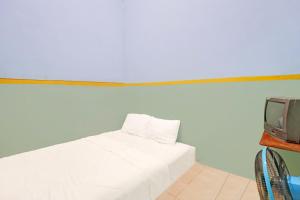 une chambre avec un lit blanc et une télévision dans l'établissement Hotel O Toyo Homestay Syariah, à Nagoya