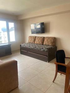 een woonkamer met een bed en een flatscreen-tv bij Antártida Argentina 63 in Ushuaia