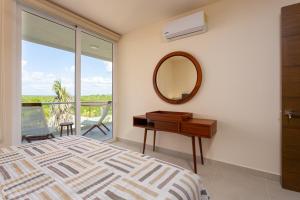 a bedroom with a bed and a mirror and a desk at Luxurious penthouse by the beach in Akumal +58 photos