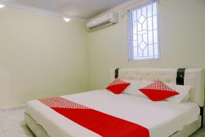 une chambre avec un lit avec des oreillers rouges et blancs dans l'établissement Hotel O Backpaker Seraya, à Nagoya