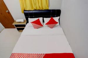 une chambre avec un lit avec des oreillers rouges et blancs dans l'établissement Hotel O Backpaker Seraya, à Nagoya 18 autres photos