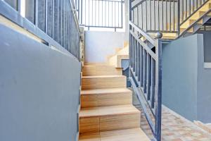 a staircase with wooden treads and metal railings at OYO Life 93032 Maju Mapan Homestay Syariah in Lamongan